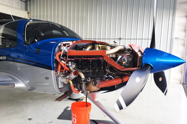 Airplane with Engine cover removed in maintenance hangar